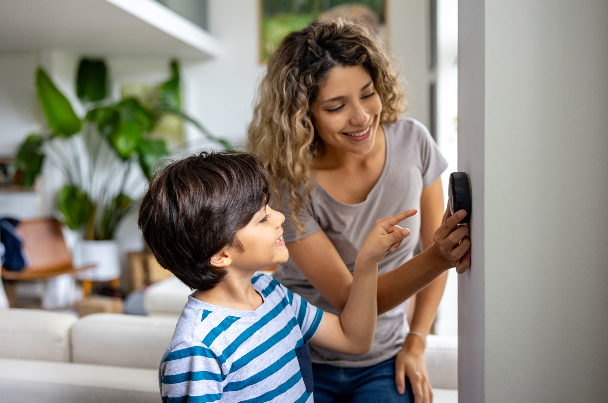 Woman and Child Using Smart Thermostat