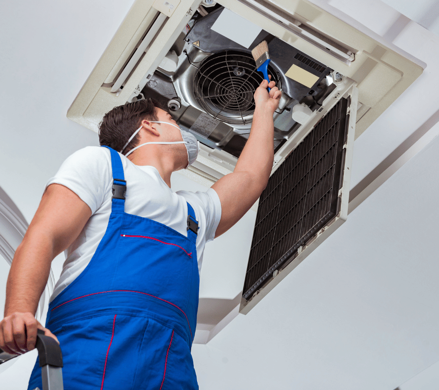 Emergency HVAC technician repairing an indoor air conditioning unit in Greater Seattle