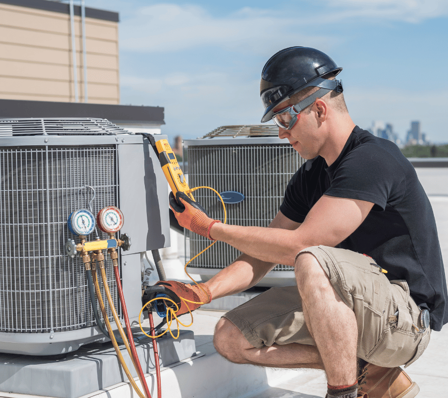 HVAC technician testing rooftop air conditioning equipment for emergency service in Greater Seattle
