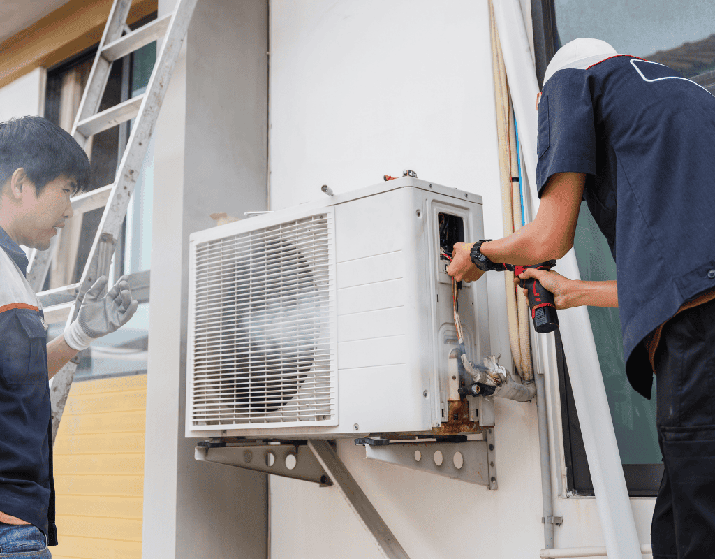 Technicians repairing an outdoor air conditioning unit for cooling service in Greater Seattle
