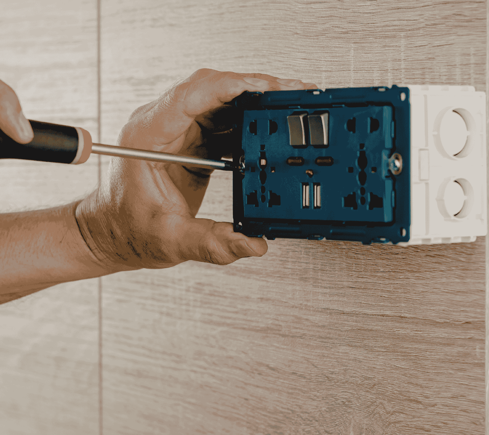 Electrician installing a wall outlet during residential electrical service in Greater Seattle